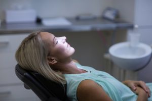 woman relaxing in dental chair under dental sedation