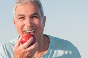 A man eats an apple following his bone grafting procedure.