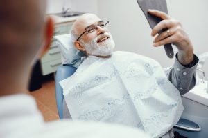 A man is smiling at the results of his bone grafting procedure.