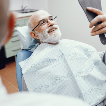 A man is smiling at the results of his bone grafting procedure.