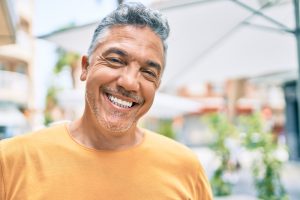 a man smiles beautifully with immediate load dental implants